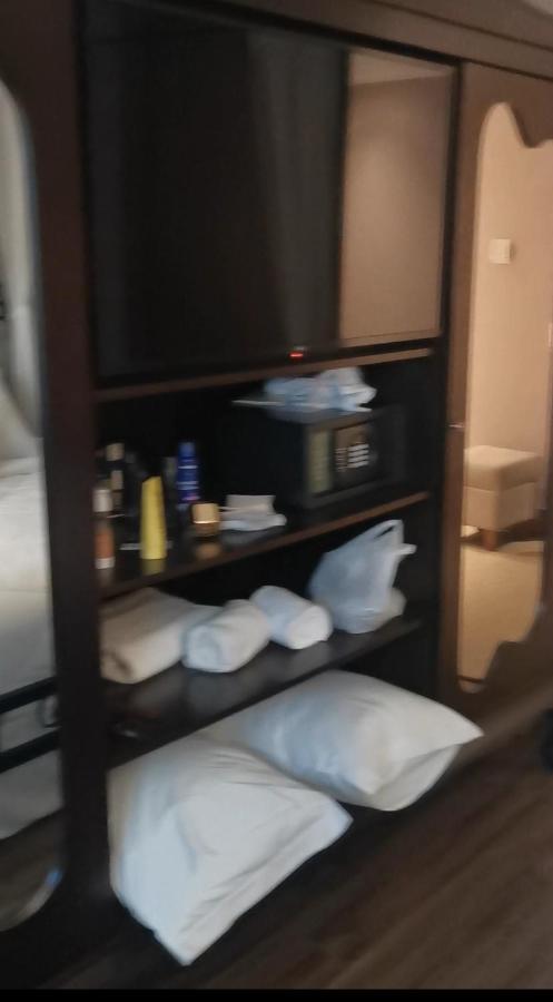Buona Vitta Gramado Resort & Spa By Gramado Parks 외부 사진 The photo shows a piece of furniture, likely a shelving unit or cabinet, with several items on it. There is a television mounted on top. Below the TV, there is a microwave and a small safe. The shelves contain various toiletries and personal care pro
