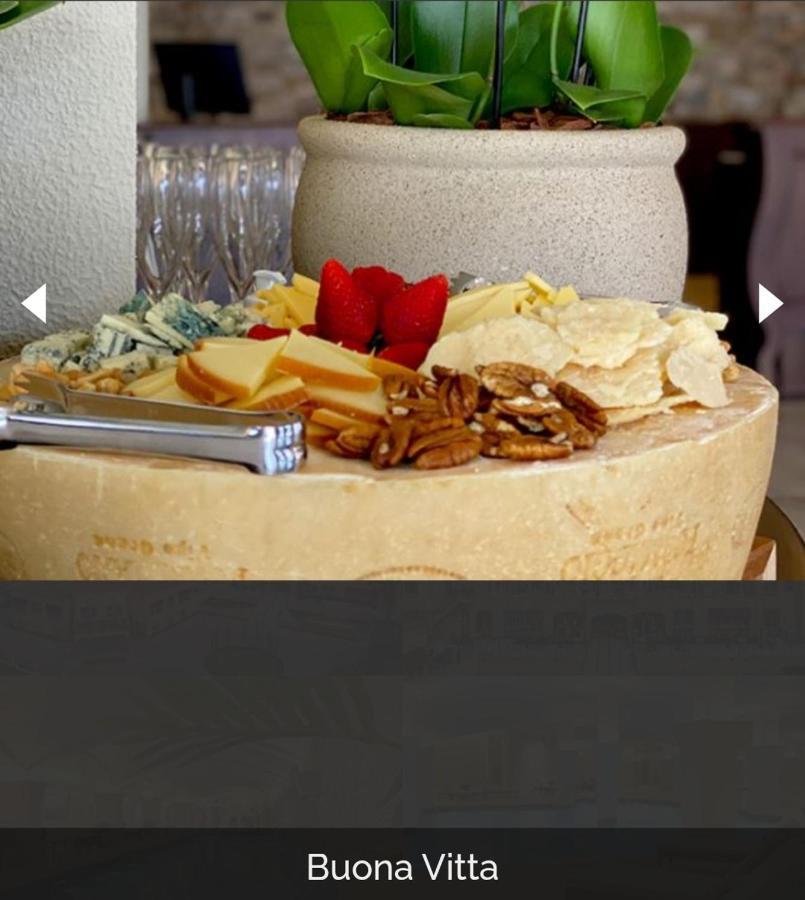 Buona Vitta Gramado Resort & Spa By Gramado Parks 외부 사진 The photo displays a beautiful cheese platter. It features a large round cheese wheel as the base, surrounded by various types of cheeses including soft and hard varieties. There are also some crackers or crisps, along with nuts, particularly pecans.
