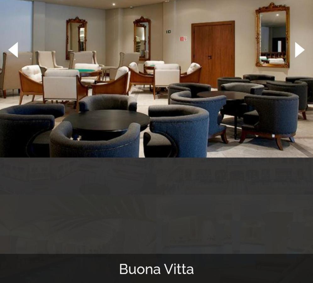 Buona Vitta Gramado Resort & Spa By Gramado Parks 외부 사진 The photo shows a modern, elegantly designed lounge or waiting area. It features several circular seating arrangements with dark blue armchairs surrounding black tables. In the background, there are light-colored lounge chairs and a wooden door leadi