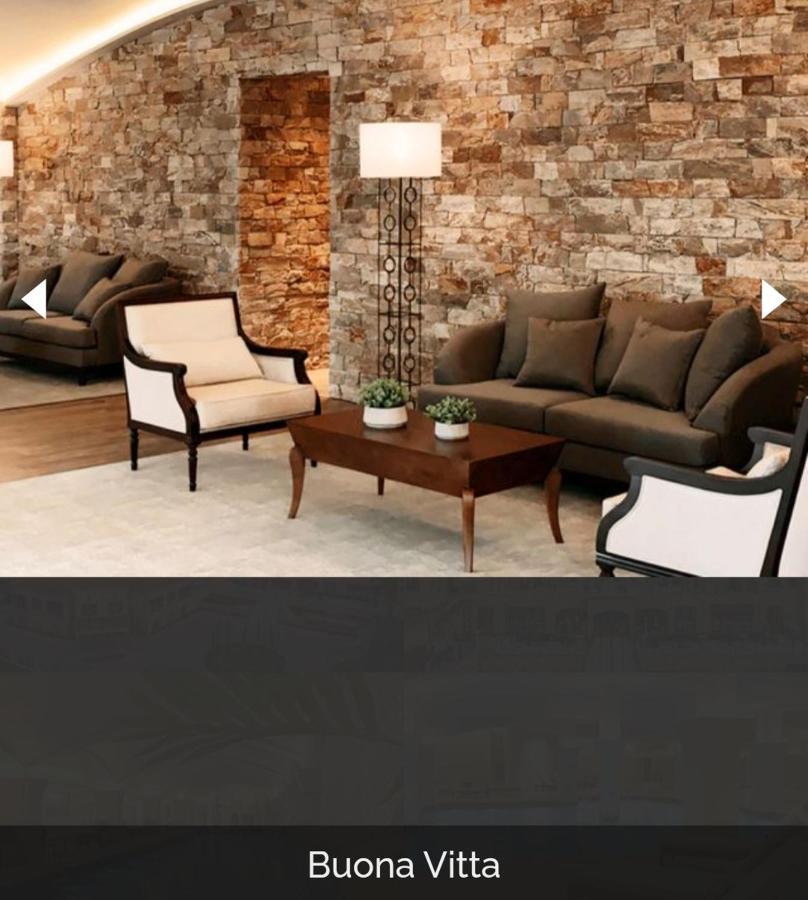 Buona Vitta Gramado Resort & Spa By Gramado Parks 외부 사진 The image shows a stylish living room setting. There are two sofas: one is a dark brown color, and the other is a cream color with dark wooden accents. In the center, there is a wooden coffee table with a smooth finish and decorative plants on top. T