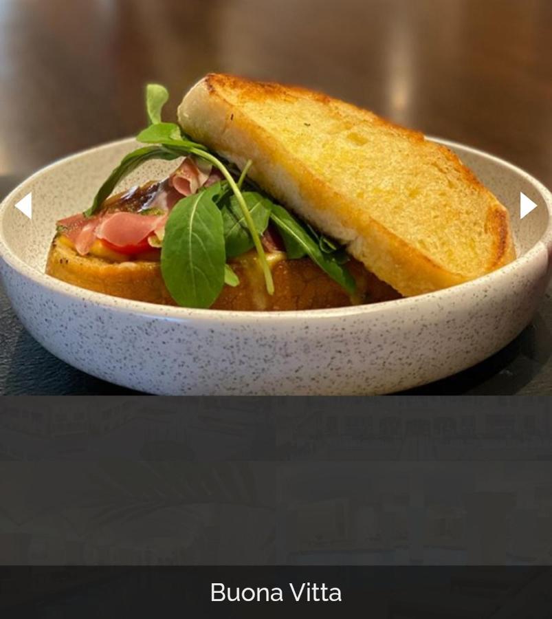 Buona Vitta Gramado Resort & Spa By Gramado Parks 외부 사진 The photo shows a dish presented in a round, speckled bowl. It features a slice of toasted bread resting on top of a combination of ingredients beneath. The ingredients include leafy greens and slices of what appears to be cured meat, possibly ham. T