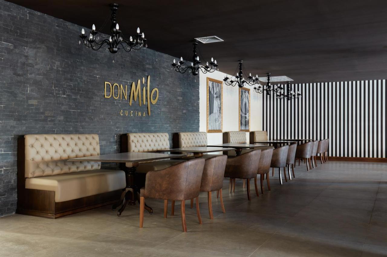 Buona Vitta Gramado Resort & Spa By Gramado Parks 외부 사진 The photo showcases an interior of a restaurant named "Don Milo." The design features a modern and sophisticated look with a mix of textures and colors. 

On one side, there are upholstered booths in a neutral tone, creating a comfortable dining area