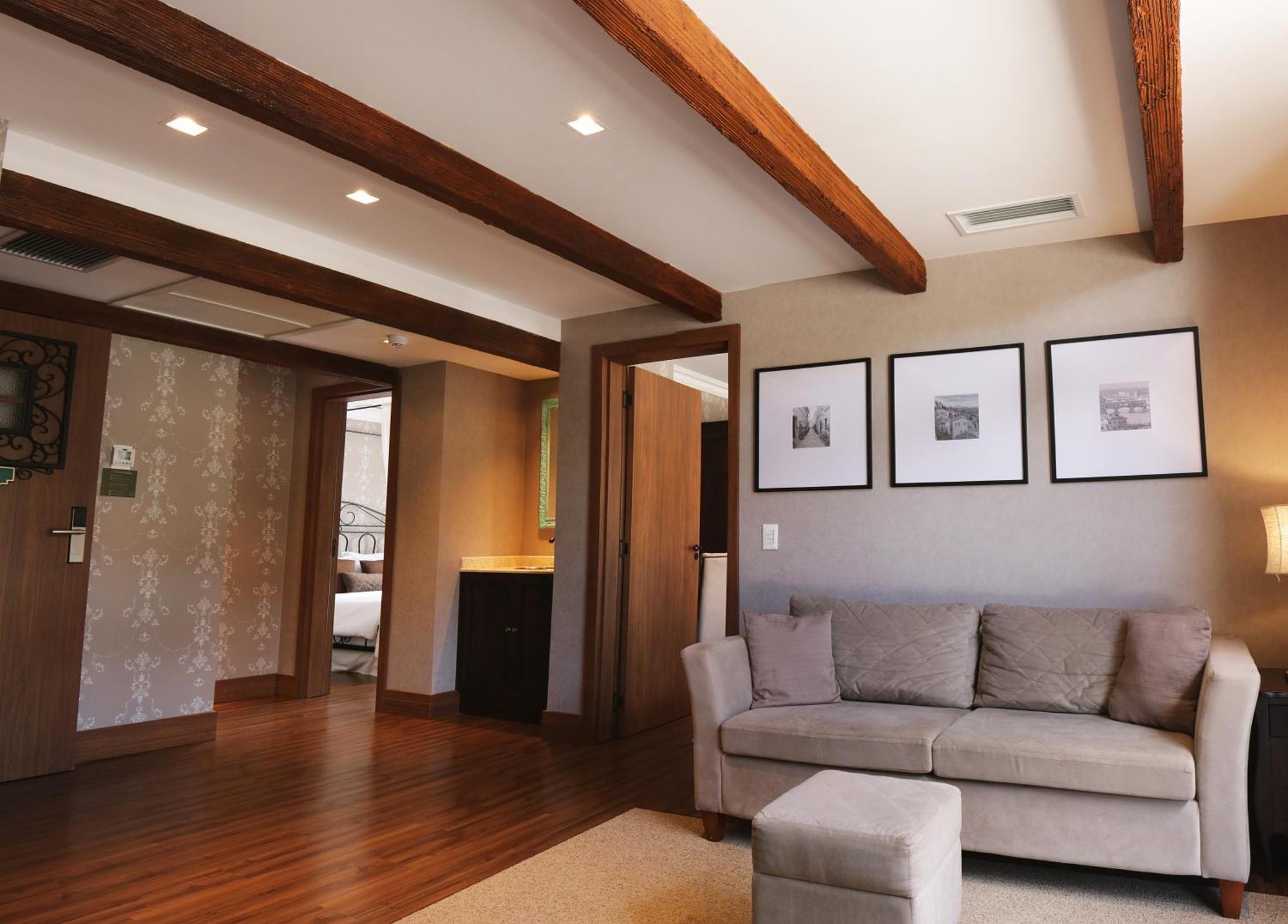 Buona Vitta Gramado Resort & Spa By Gramado Parks 외부 사진 The photo showcases a modern living space with a cozy and well-lit atmosphere. There are wooden beams visible on the ceiling, adding a rustic touch. The flooring is a warm-toned wood, contributing to the inviting feel of the room. 

On one side, ther