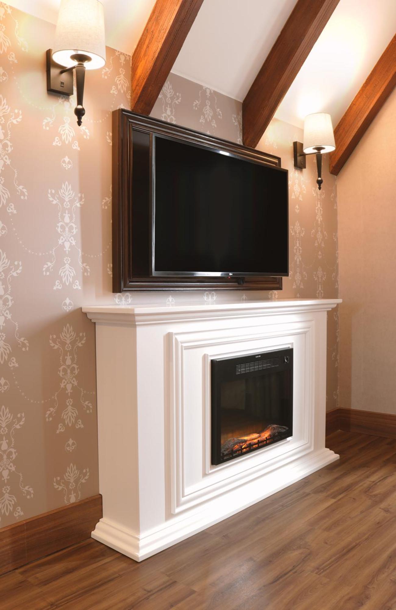 Buona Vitta Gramado Resort & Spa By Gramado Parks 외부 사진 The image shows a modern living room setup featuring a white mantel with an electric fireplace. Above the mantel, there is a large flat-screen television mounted on the wall. The fireplace has a glass front and displays a realistic flame effect, crea