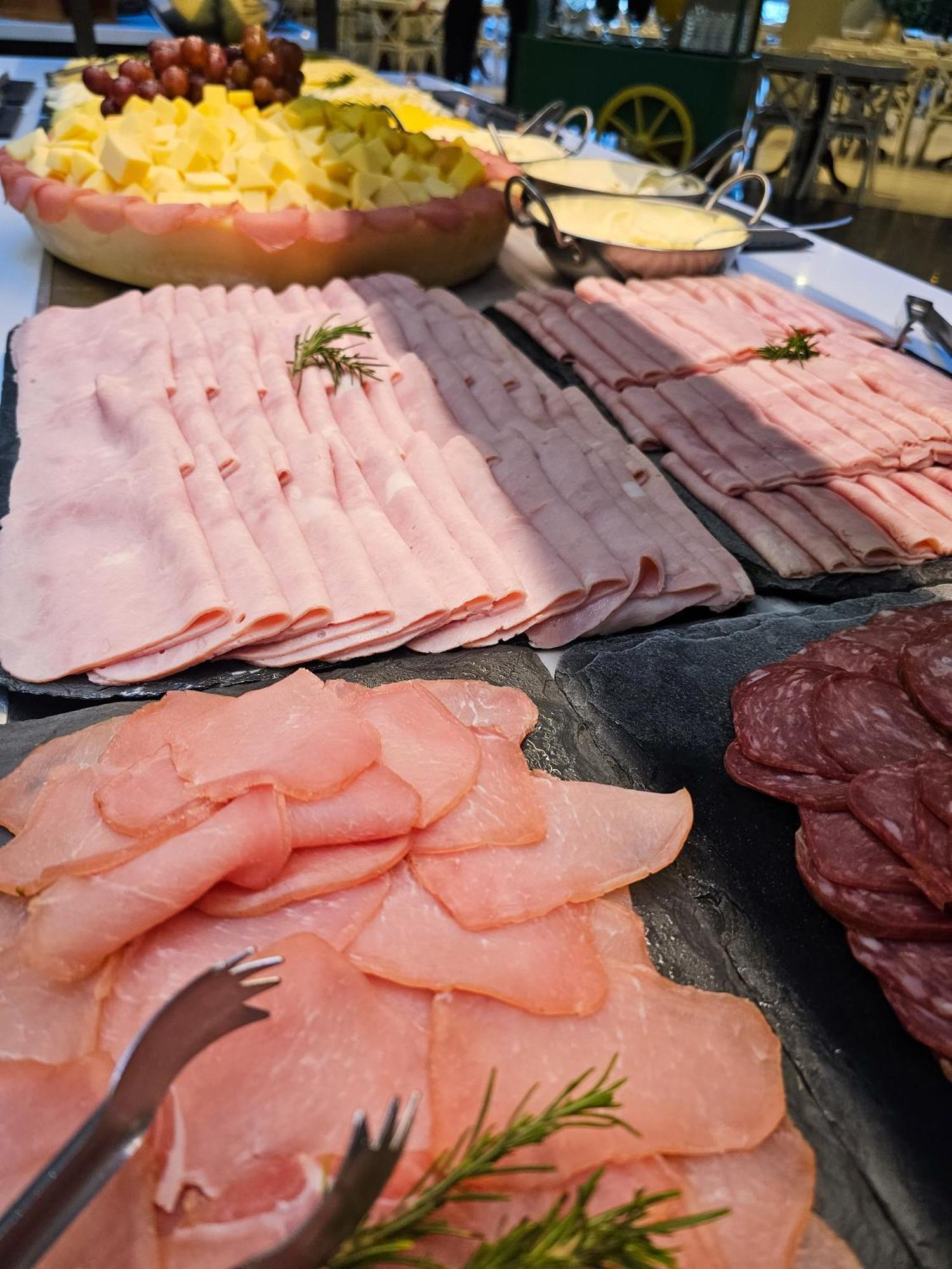 Buona Vitta Gramado Resort & Spa By Gramado Parks 외부 사진 The photo shows a display of various types of sliced deli meats arranged on a flat surface. There are several layers of thinly sliced, pale-colored meats, likely including ham or turkey, organized neatly in parallel rows. Additionally, there are slic